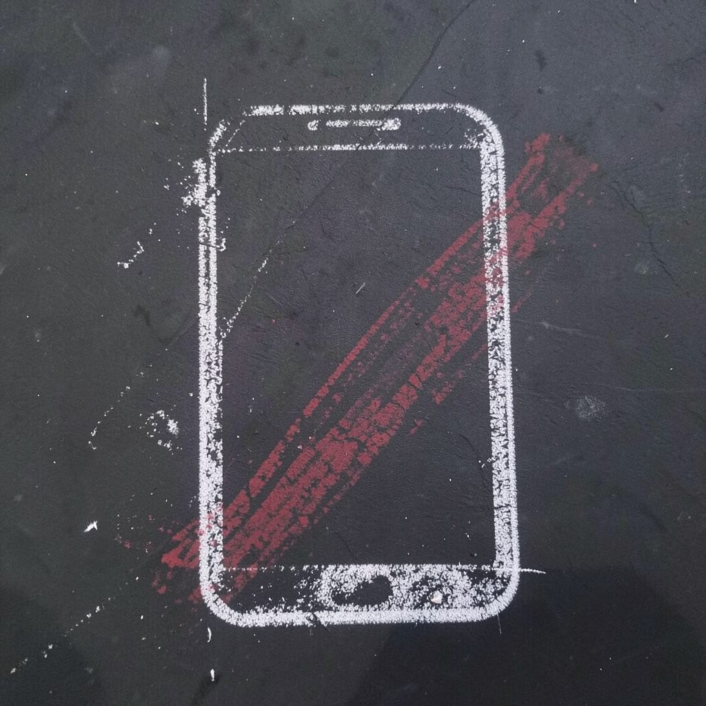 A chalk drawing on a dark slate board of a hand holding a smartphone with a film reel icon sketched in soft white chalk strokes